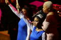 Photograph: [Chrisette Michele singing behind performers]