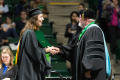 Photograph: [Masters Recipient Receiving Diploma from Faculty at Commencement Cer…