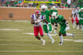 Photograph: [LA Tech player running from UNT players]