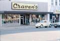 Photograph: [Man sweeping in front of Craven's store]