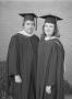 Photograph: [Two graduates posing in their caps and gowns]