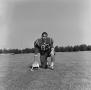 Photograph: [Football player kneeling with a helmet, 42]
