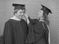 Photograph: [Graduate fixing tassel on her friend's cap]