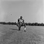 Photograph: [Football player kneeling with a ball, 21]