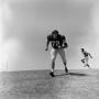 Photograph: [Football player #72, K. O'Neil, jogging down a inclined grass field …