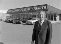 Photograph: [Man standing in front of a Pontiac-Toyota dealership, 2]