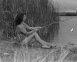 Photograph: [Woman posing as Ghost River Kid while fishing]