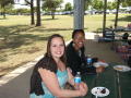 Photograph: [Two TNT members at table under pavilion]