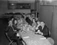 Photograph: [Group eating at long table]