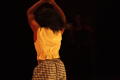 Primary view of [Photograph of a closeup of a dancer on stage with his back to the camera]