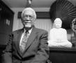 Photograph: [Dr. Donald A. Brooks seated with Buddha statue #2]