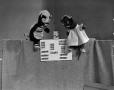 Photograph: [Two puppets and a band-aid box]