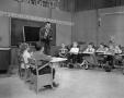 Photograph: [Students sitting in a classroom film set]