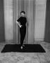Photograph: [Photo of Ann Alden standing on a rug]
