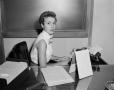 Photograph: [Secretary sitting at her desk 2 of 2]