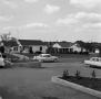 Photograph: [Photograph of a car driving by the Westcliff Shopping Center]