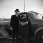 Photograph: [Photograph of a couple posing by an automobile]