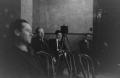 Photograph: [Photograph of men sitting in chairs behind a camera]