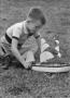 Primary view of [Photograph of Tim Williams playing with a toy boat, 2]