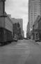 Primary view of [Photograph of a street lined with tall buildings]