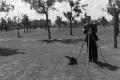 Primary view of [Photograph of Byrd Williams III setting up a tripod outdoors, 3]