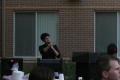 Photograph: [Jonathan Gallegos speaking and pointing at dorm barbecue]