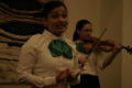 Photograph: [Mariachi singer and violinist at 2004 La Raza performance]