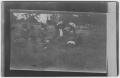 Photograph: [Four individuals sitting outside in the grass]