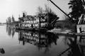 Photograph: [A dilapidated boat along a river]