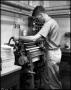 Photograph: [Book Bindery - Process - Male Individual - Roller - 1963]