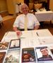 Photograph: [Man sits at literature table during TXSSAR Dallas Chapter meeting]