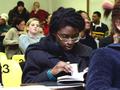 Photograph: [UNT student flips through book during class]