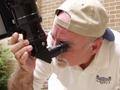 Photograph: [Sky Theater staff member uses telescope]