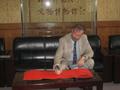 Photograph: [Warren Burggren signs autograph book at BNU China]