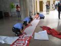 Photograph: [Group assembles banner with Chinese characters]