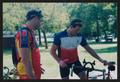 Photograph: [Two cyclists inspecting a bike: Lone Star Ride 2002 event photo]
