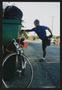 Photograph: [Cyclist stretching by a garbage can: Lone Star Ride 2002 event photo]