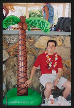 Primary view of object titled '[Medical crew member sitting by an inflatable palm tree: Lone Star Ride 2005 event photo]'.