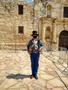 Thumbnail image of item number 1 in: '[The Alamo historical site with reenactor wearing a face mask]'.
