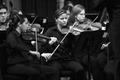 Photograph: [Violinists perform with UNT orchestra]