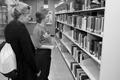Photograph: [Library employee helps student find book, 2]