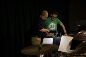 Primary view of object titled '[Two people reviewing music sheet behind the scenes at the Jazz Ambassadors Syndicate Performance]'.