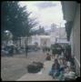 Photograph: [People walking down and sitting alongside a street in Tarabucu]
