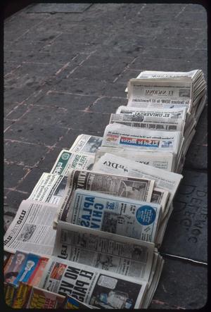 Primary view of object titled '[Stacks of newspapers on the ground]'.