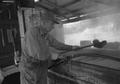 Photograph: [Hulen Wilcox standing next to the sugar cane evaporator]