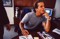 Photograph: [Mike Modano resting his elbows on a desk while he pauses signing aut…