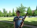 Photograph: [A man in a striped, blue t-shirt posing with a bassoon]