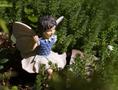 Primary view of [Angelic serenity: Statue of a little girl embraced by nature's splendor]