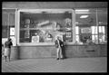 Photograph: [Man Standing in Front of a German Window Display]