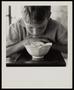 Photograph: [A boy looking into a bowl, 1]